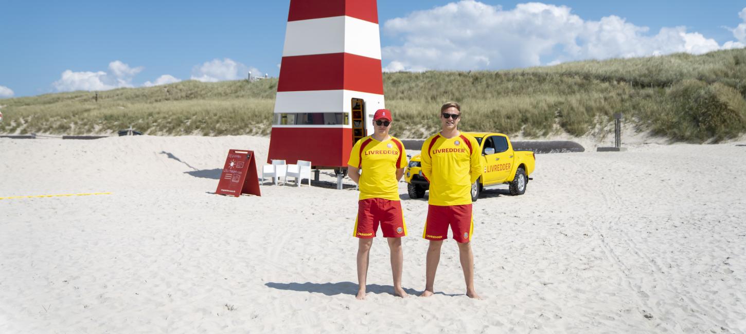 To livreddere står på stranden